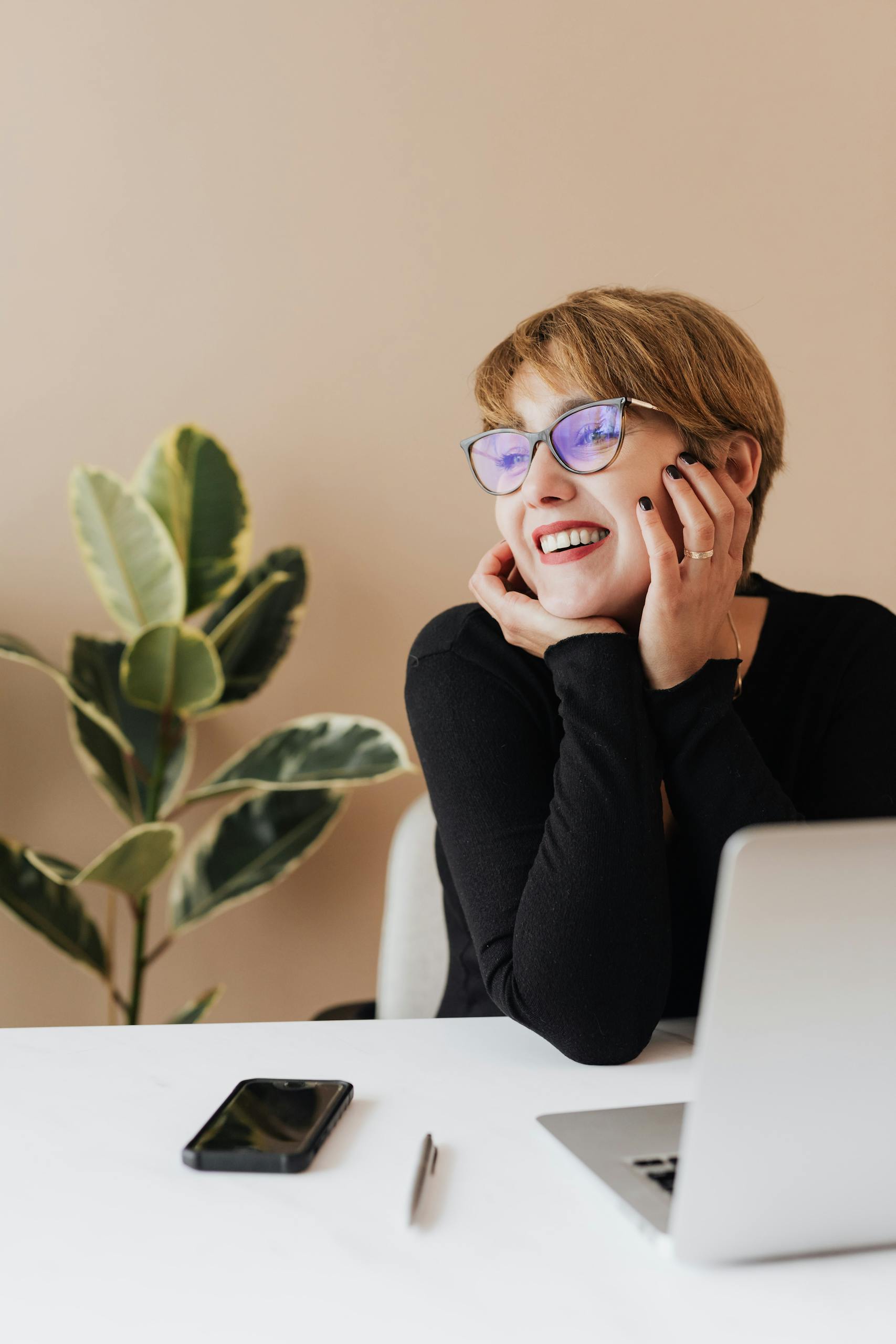 Cheerful woman working on laptop and smiling